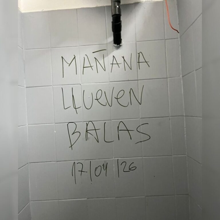 Ilustración de un aula escolar vacía con un mensaje de advertencia sobre la seriedad de las amenazas.