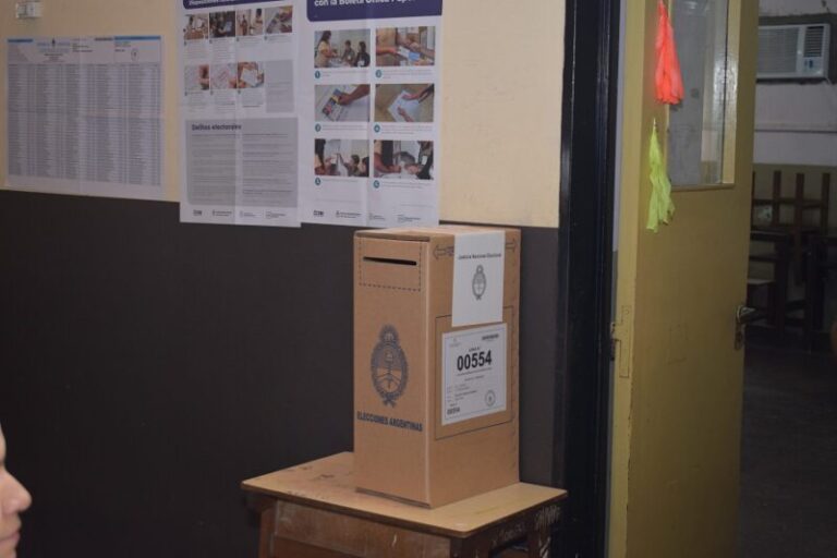 Ilustración de una urna de votación y documentos legislativos sobre un escritorio.