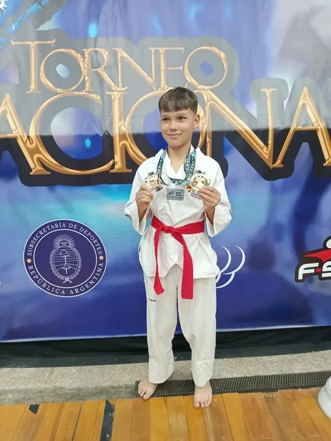 Lauriano Acevedo, niño de 10 años con uniforme de taekwondo y medallas, en Santo Tomé, Corrientes