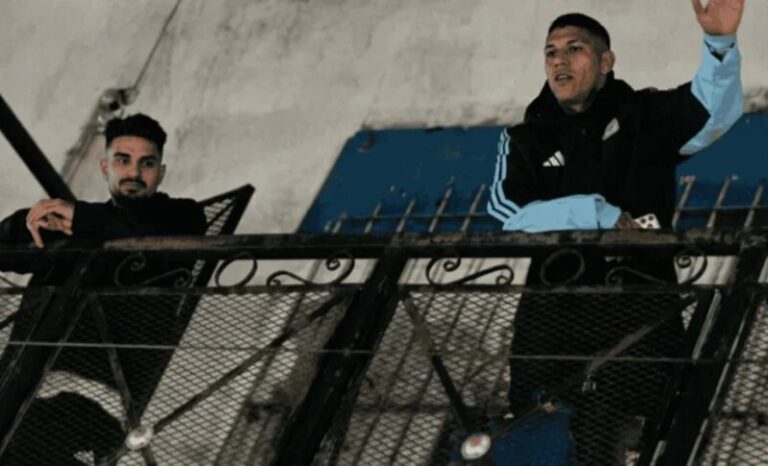 Facundo Medina y José Manuel López desde un balcón en Villa Caraza, rodeados de vecinos
