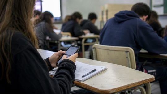 Estudiante leyendo un libro impreso en una biblioteca