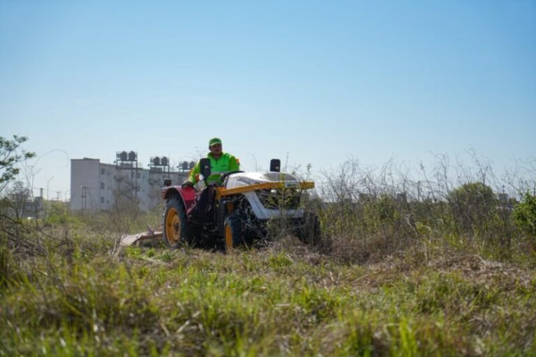 Tractor municipal realizando tareas de desmalezamiento en un camino de Corrientes