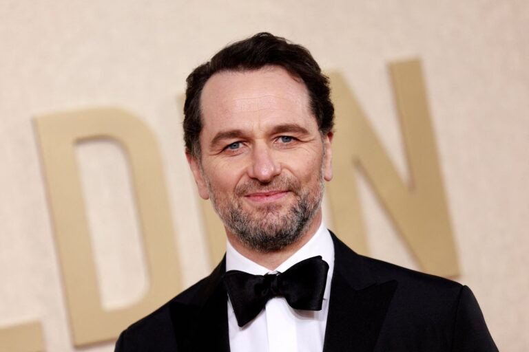 Matthew Rhys sonriendo con un premio Emmy en la mano