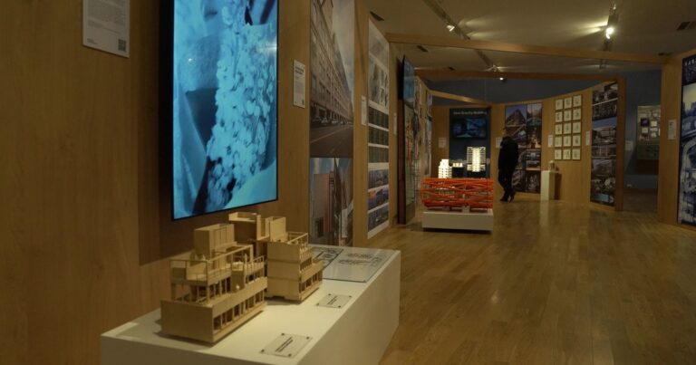 Vista de la exposición Habitar en el Museo Nacional de Bellas Artes, con paneles de madera y maquetas de arquitectura