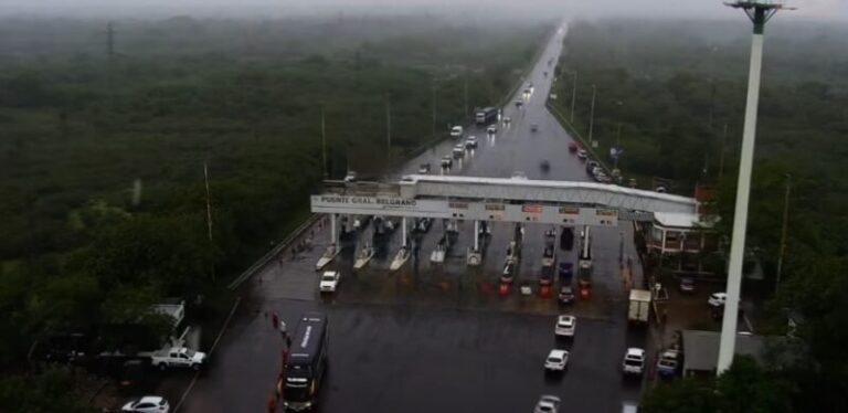 Automovilistas esperan bajo la lluvia para tramitar la oblea de telepeaje en el peaje del puente General Belgrano, entre Corrientes y Chaco.